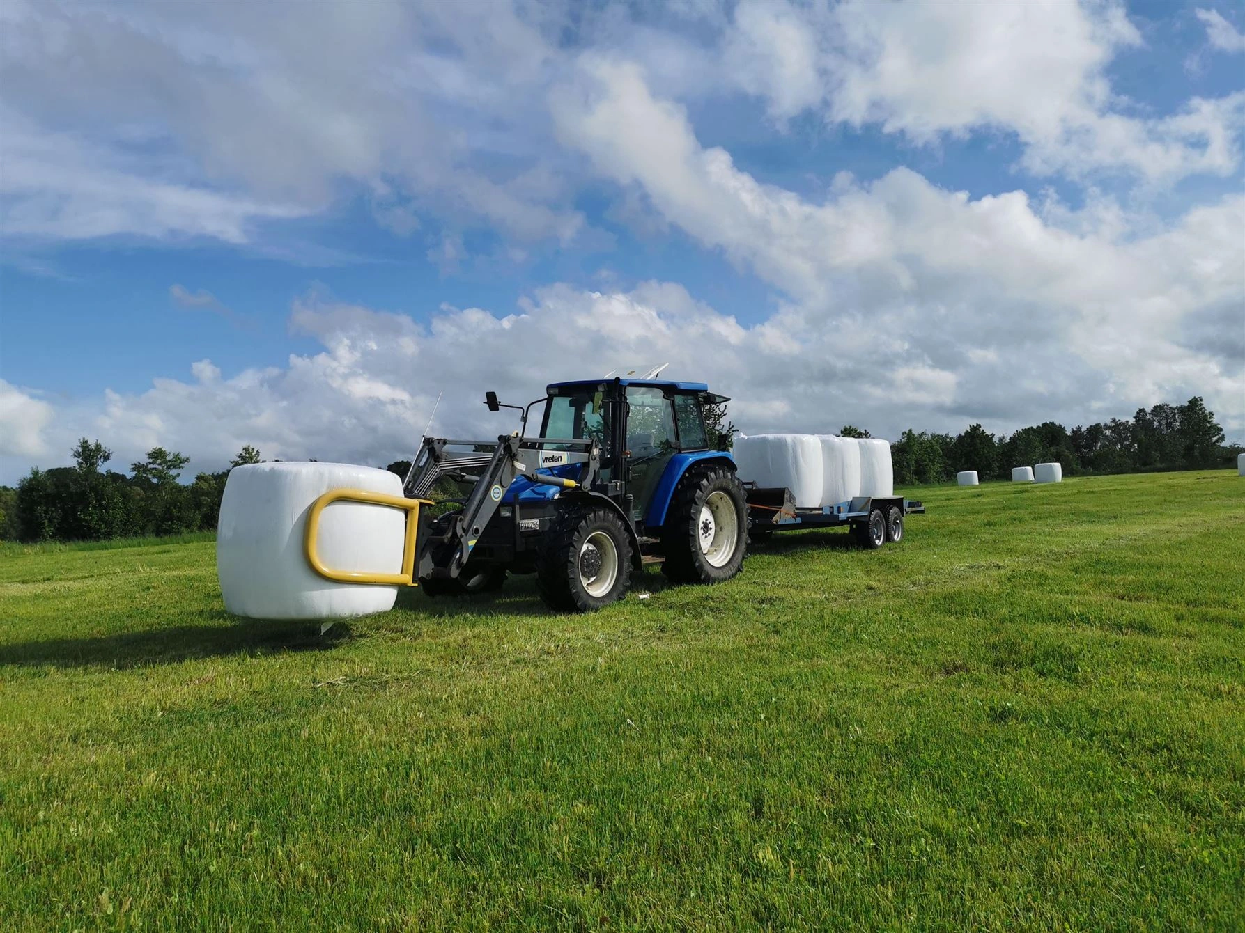 Blå traktor med balar